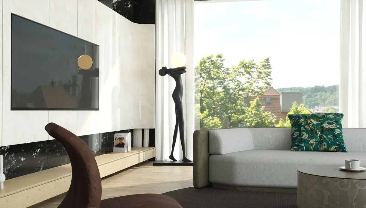 Lampada da terra a forma di figura femminile stilizzata nera che sorregge una sfera luminosa, accanto a una grande finestra con vista sugli alberi, divano grigio e parete attrezzata in marmo chiaro e nero